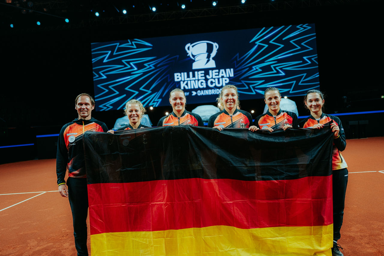 Rainer Schüttler, Laura Siegemund, Jule Niemeier, Anna-Lena Friedsam, Tatjana Maria und Eva Lys halten eine Deutschlandfahne in ihren Händen. Fotograf Philipp Reinhard