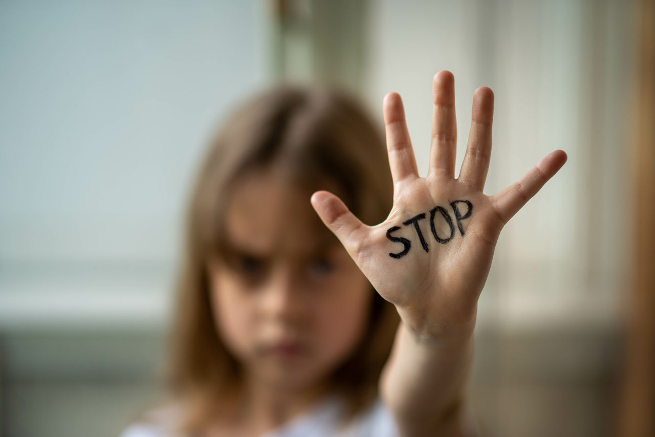 The child makes a stop gesture with his hand. Stop domestic and child abuse. Protecting the rights of children.