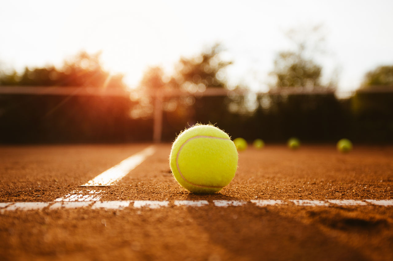 Tennisball auf der Grundlinie eines Sandplatzes