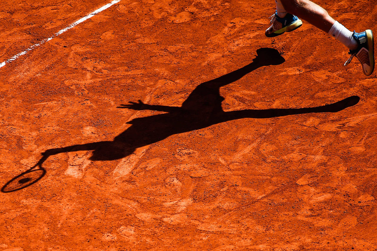 Cute little boy with tennis racket and ball on court outdoors