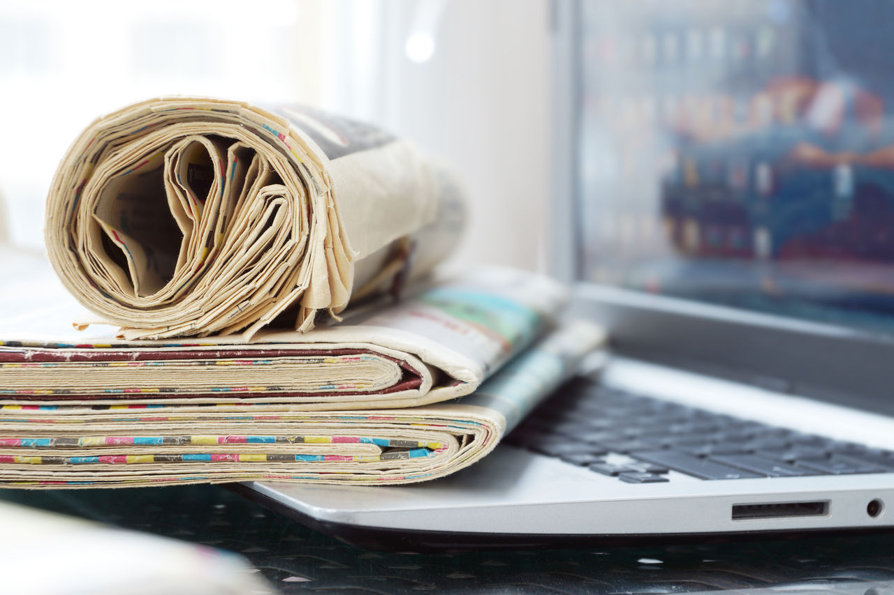 Newspapers and Laptop. Different Concepts for News -  Network or Traditional Tabloid Journals. Data Sources - Electronic Screen of Computer or Paper Pages of Magazines, Internet or Papers
