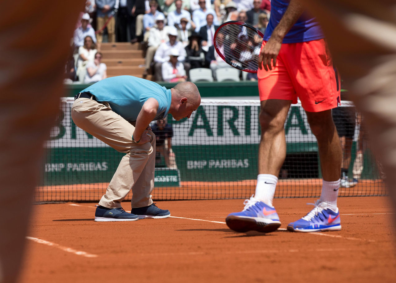 French Open 2015 , Stuhlschiedsrichter Pascal Maria geht in die Knie und pruefed den Ballabdruck auf der Linie,fotografiert durch die Beine des Linienrichters, Tennis - French Open 2015 - Grand Slam ITF / ATP Tennis Herren / WTA Tennis Damen - Roland Garros - Paris - - France - 27 May 2015. Juergen Hasenkopf