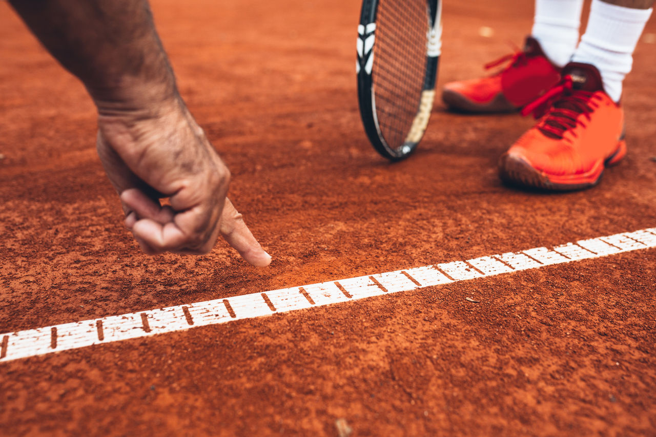 close up of referee showing that the ball was out on tennis court