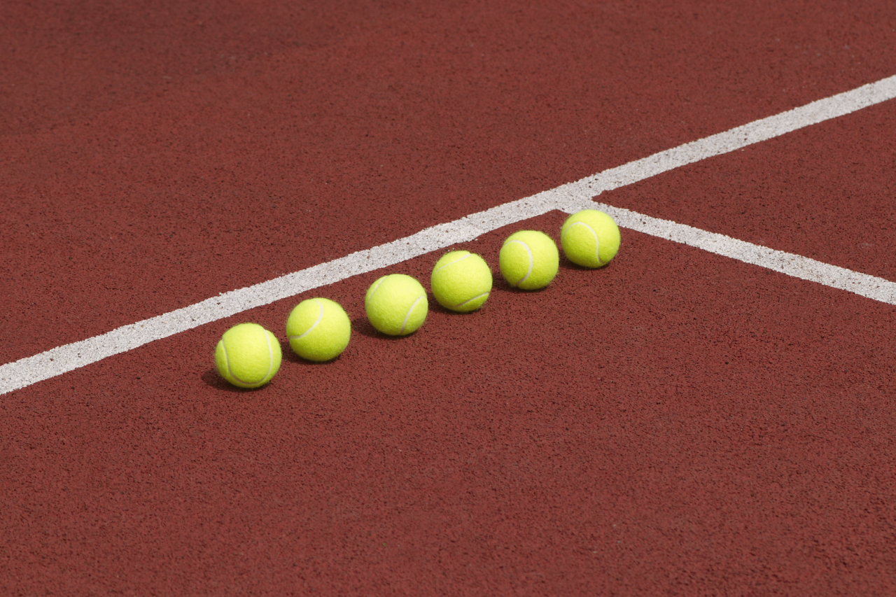 Sechs Tennisbälle auf einem Tennisplatz
