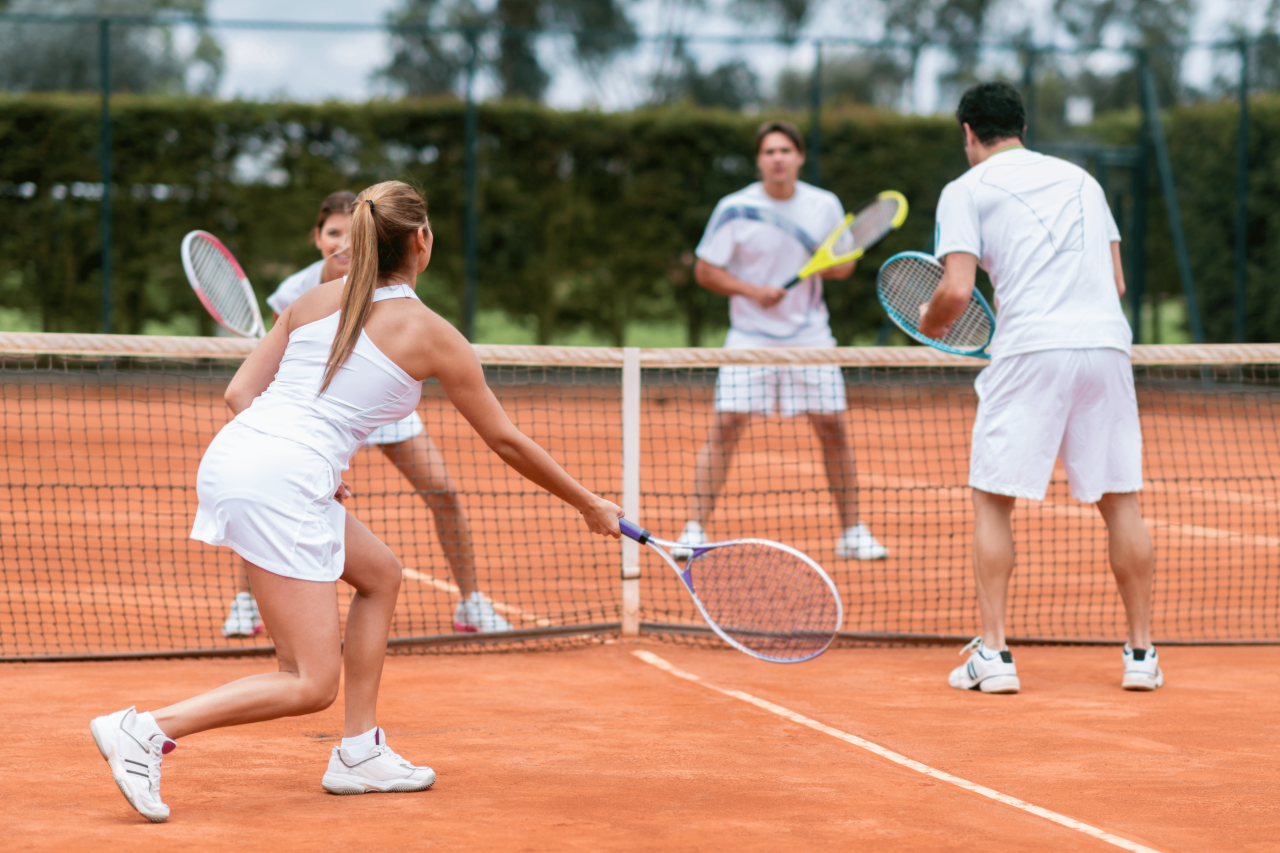 zwei Mixed-Doppel spielen Tennis