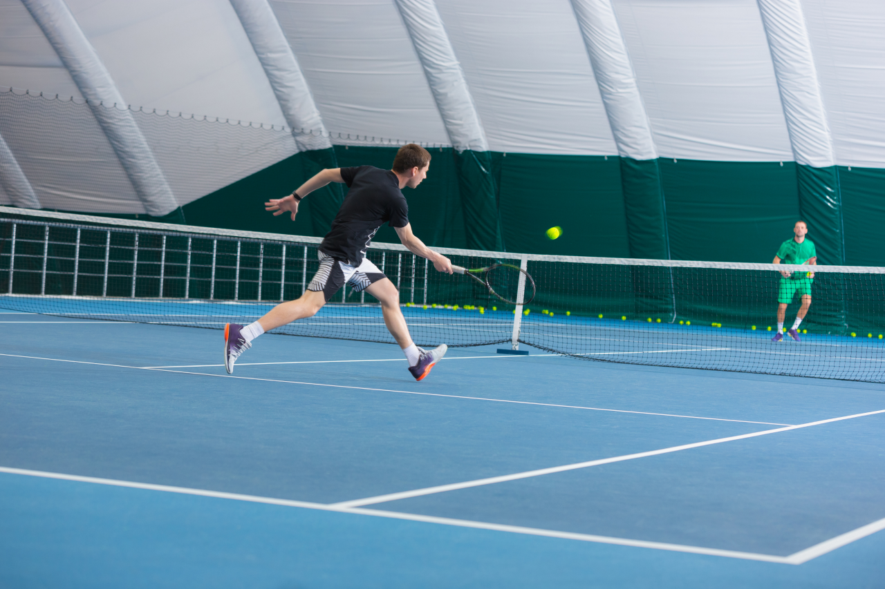 Hallenplatz mit zwei Tennisspielern gegeneinander