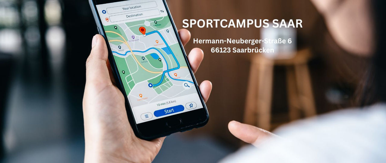 Hand, die ein Handy hält, auf welchem eine Navigation zum Ziel angezeigt wird