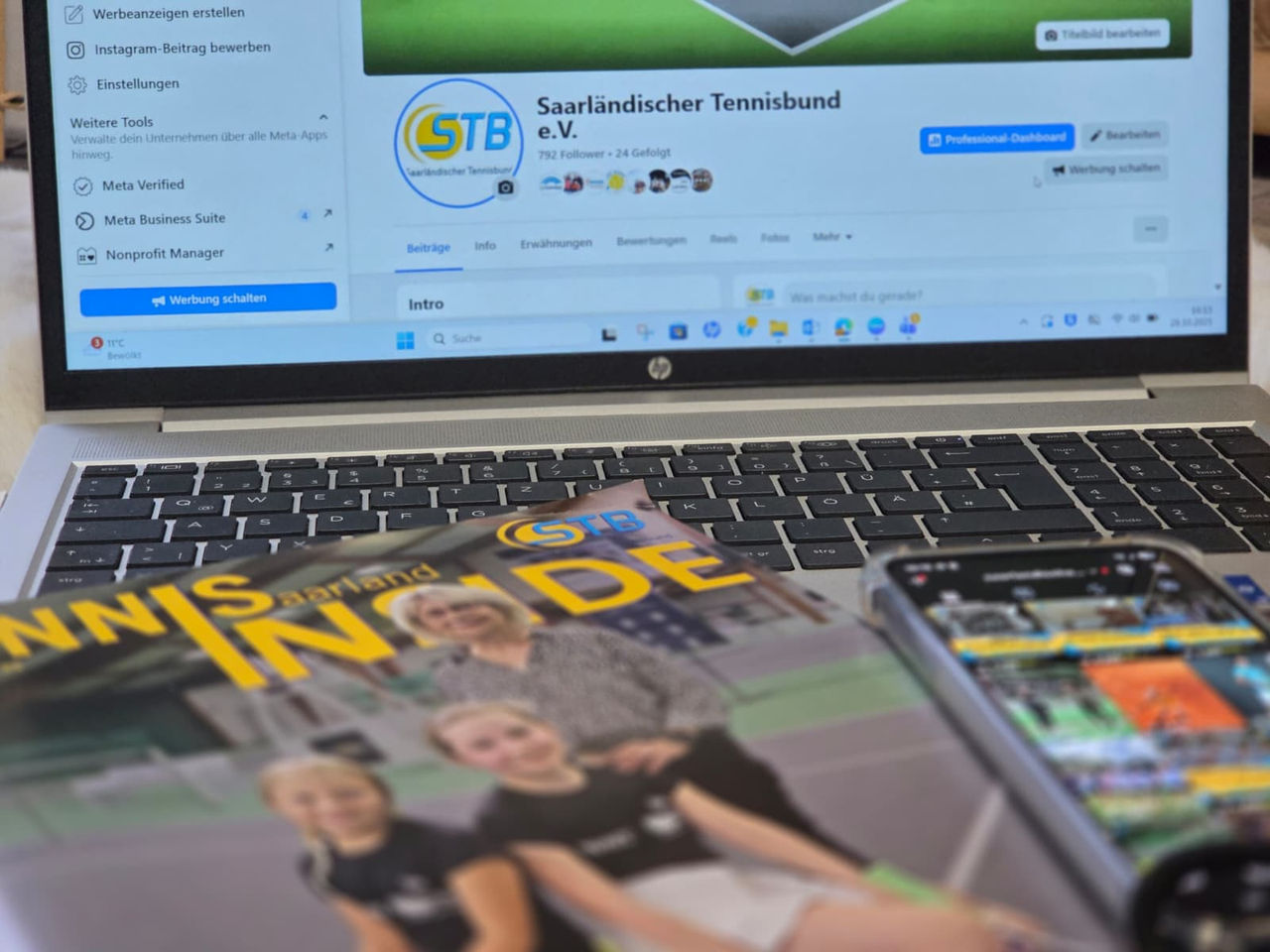 Aufgeklappter Laptop mit Facebookseite offen, davor liegend das Verbandsmagazin und ein Handy mit Instagram offen