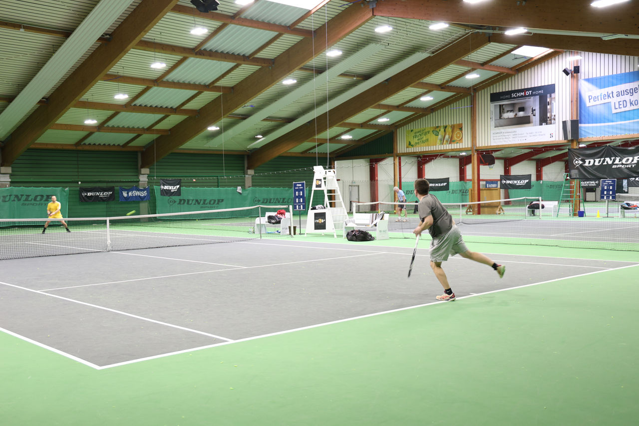 Match zwischen zwei Tennisspieler in der Tennishalle mit grauem Feld und grünem Boden