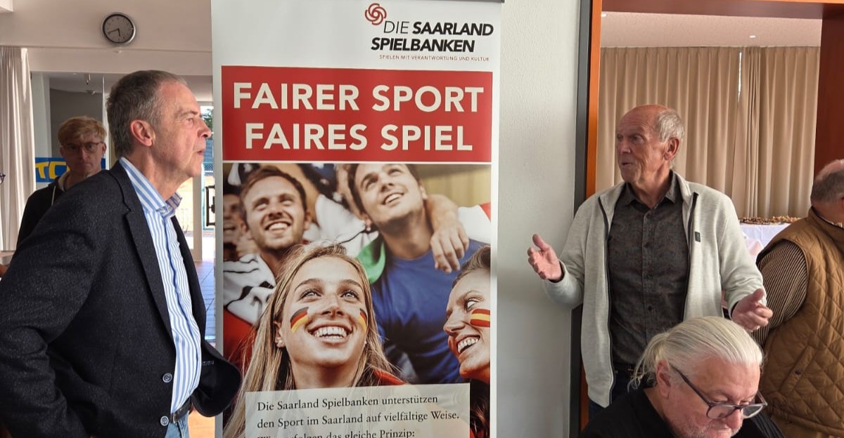 Siegerehrung mit dem Präsidenten des STB und Harald Bruch von den Saarland Spielbanken vor einem Plakat. Aufschrift: Fairer Sport, faires Spiel