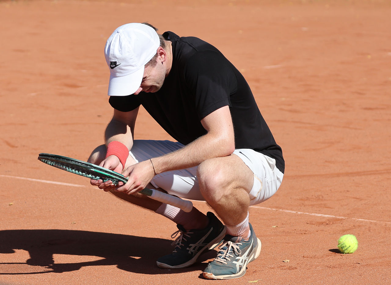 Spieler kniet auf dem Boden und schaut schläger an