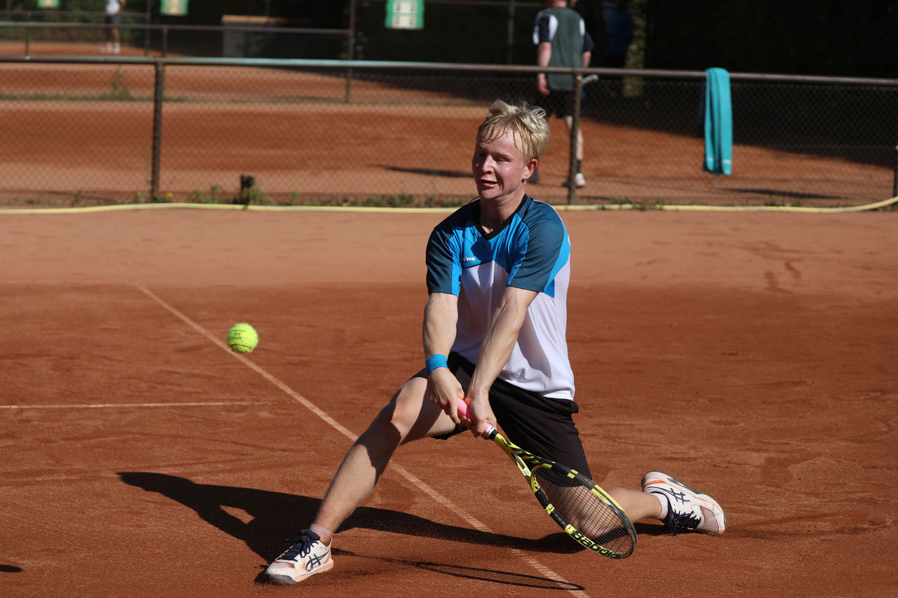Spieler rutscht auf Sand und spielt den Ball