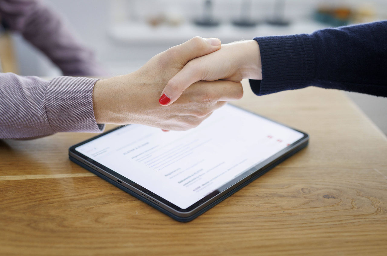 Symbolfoto zum Thema Vertragsabschluss. Handschlag zwischen Mann und Frau ueber einem Tablet mit einem Textdokument auf dem Bildschirm. Berlin, 13.08.2024. Berlin Deutschland *** Symbolic photo on the topic Contract signing Handshake between man and woman over a tablet with a text document on the screen Berlin, 13 08 2024 Berlin Germany Copyright: xUtexGrabowsky/photothek.dex